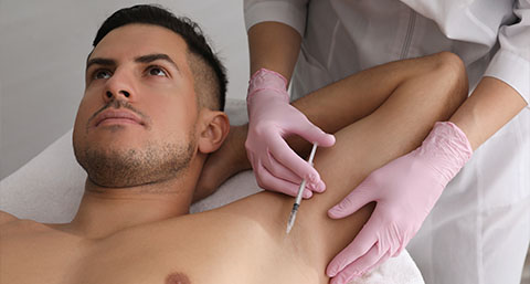 a man receiving an injection to the underarms for a Axillary Hyperhidrosis treatment